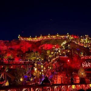Una location all'aperto su più livelli, ricavata in una parete rocciosa, illuminata di notte da centinaia di lampade e lanterne dai toni caldi.