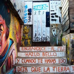 Una stretta scalinata esterna coperta di graffiti colorati, con un grande murale sulla parete sinistra e scritte a mosaico sui gradini.