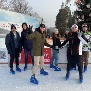 Un grupo de WeRoad sonríe y posa para una foto en una pista de patinaje sobre hielo al aire libre.