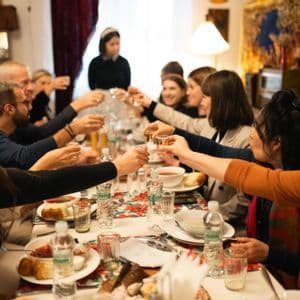 Un gruppo WeRoad a un lungo tavolo da cena, alza i calici per un brindisi.