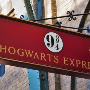 Ein rotes Hogwarts Express Schild mit der Nummer 9 3/4 hängt an einer Ziegelwand.