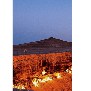 Due persone di un viaggio di gruppo WeRoad si trovano accanto a una ringhiera, guardando un grande cratere di gas infuocato nel deserto al tramonto.