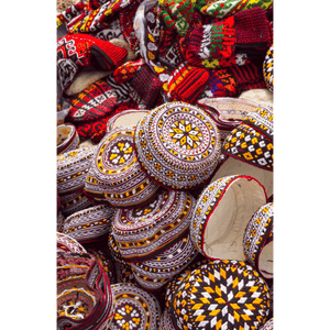 Un grande mucchio di colorati zuccotti e berretti di lana tradizionalmente ricamati con vari motivi geometrici.