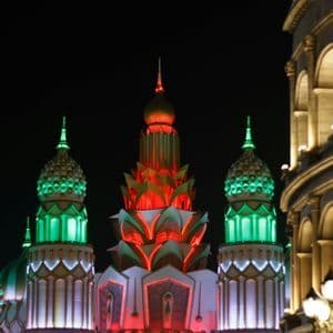 Die wie Lotusblumen geformten Türme eines verzierten Gebäudes werden rot und grün vor dem Nachthimmel beleuchtet.