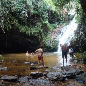 Un viaggio di gruppo WeRoad per nuotare e rilassarsi in una piscina naturale ai piedi di una cascata in una grotta lussureggiante e verde.