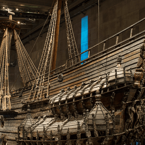 Una grande e storica nave da guerra in legno, con intarsi intricati sullo scafo e sulla prua, esposta all'interno di un museo.