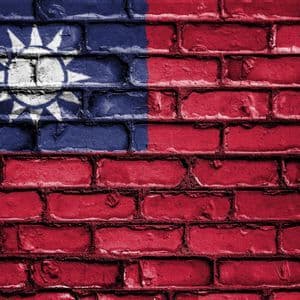 Die Nationalflagge Taiwans, gemalt auf eine strukturierte rote Backsteinmauer.