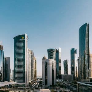Un fitto paesaggio urbano di moderni grattacieli dall'architettura unica che si stagliano sotto un cielo azzurro e limpido.