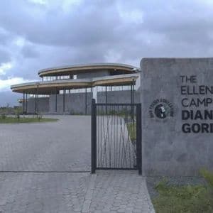 Le panneau d'entrée du Campus Ellen DeGeneres du Fonds Dian Fossey pour les Gorilles, avec le bâtiment moderne visible derrière un portail.