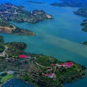 Vue aérienne d'un vaste lac turquoise entouré de péninsules et d'îles verdoyantes et vallonnées avec de petits villages.