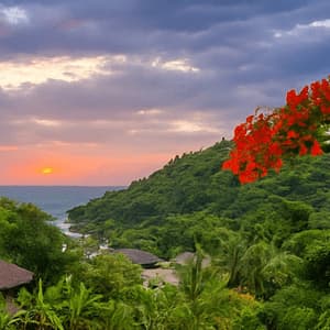Le soleil se couche sur une baie océanique calme, entourée de collines verdoyantes, avec une branche de fleurs rouges au premier plan.