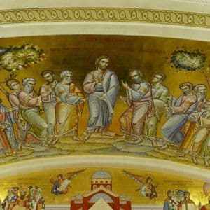 Un mural de estilo bizantino sobre un fondo dorado que representa a Jesucristo de pie y enseñando a sus doce apóstoles.