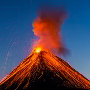 Geschmolzene Lava speit aus dem Gipfel eines ausbrechenden Vulkans und fließt in hellen Strömen dessen Hänge unter blauem Himmel hinab.