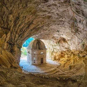 Un tempio ottagonale con cupola, costruito all'interno dell'imboccatura di una grande grotta rocciosa, visto dall'interno.