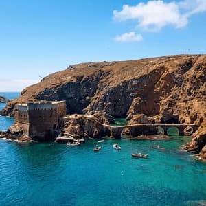 Un antico forte di pietra con un ponte ad arco si erge su una costa rocciosa, e piccole imbarcazioni galleggiano nelle acque turchesi della baia sottostante.