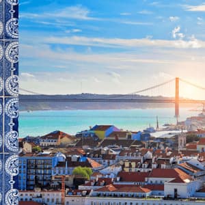 Una colonna di piastrelle a motivi blu e bianchi sulla sinistra incornicia una vista della città con un ponte sospeso sull'acqua al tramonto.