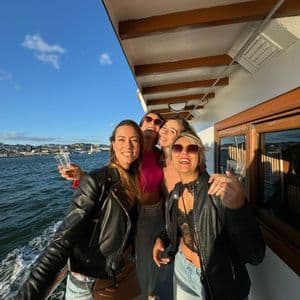 Un viaggio di gruppo WeRoad di quattro donne che sorridono e posano per una foto sul ponte di una barca in mare.