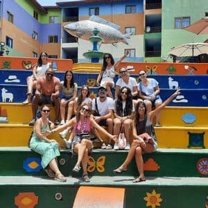 Un grupo de WeRoad posa para una foto en una amplia escalera de colores brillantes decorada con símbolos.