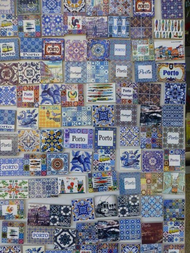 Portugiesische Souvenirmagnete mit blau-weißen Azulejo-Kachelmotiven, Hähnen und dem Schriftzug 'Porto'.