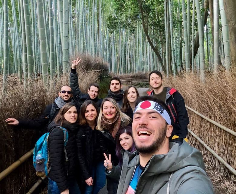 A WeRoad group trip smiles for a selfie on a path through a dense green bamboo forest.