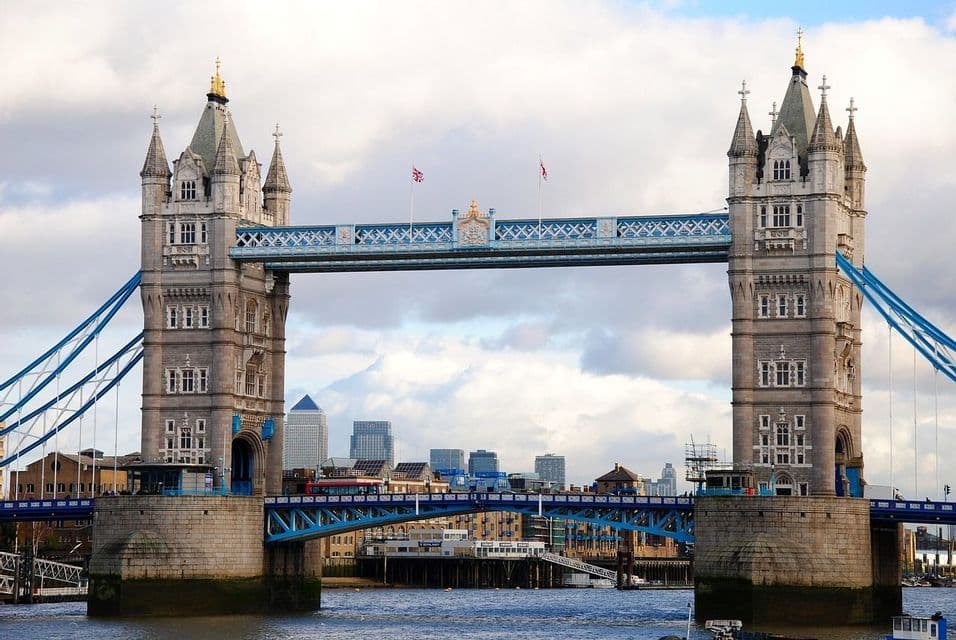 Vista frontale del Tower Bridge a Londra, sul fiume Tamigi, con lo skyline della città sullo sfondo.