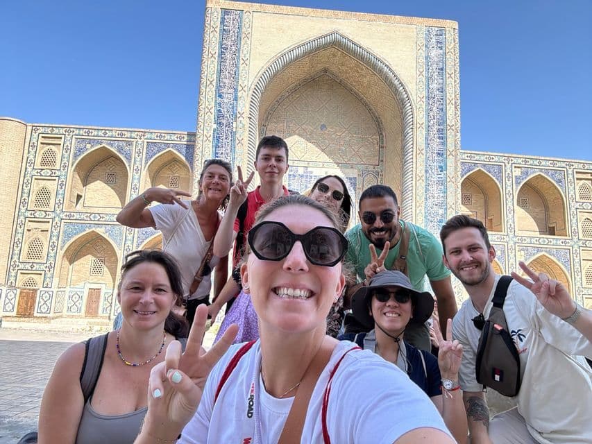 A WeRoad group trip takes a smiling selfie, making peace signs in front of an ornate, tiled historical building.