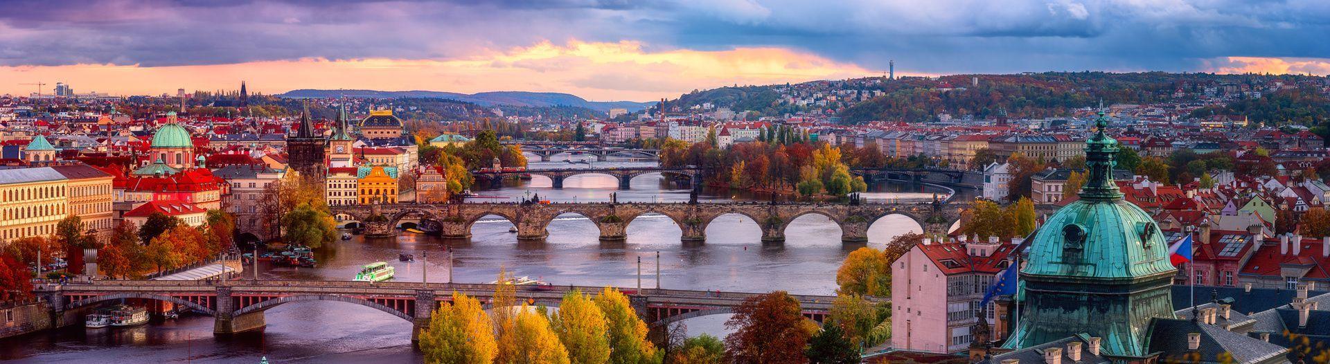 The bridges of Prague over the Vltava river surrounded by autumn colours.