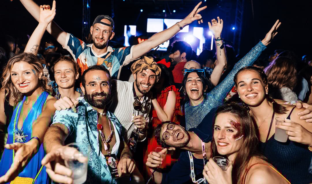 Viaggio di gruppo WeRoad: sorrisi e pose a una festa notturna, con trucco glitter e drink.