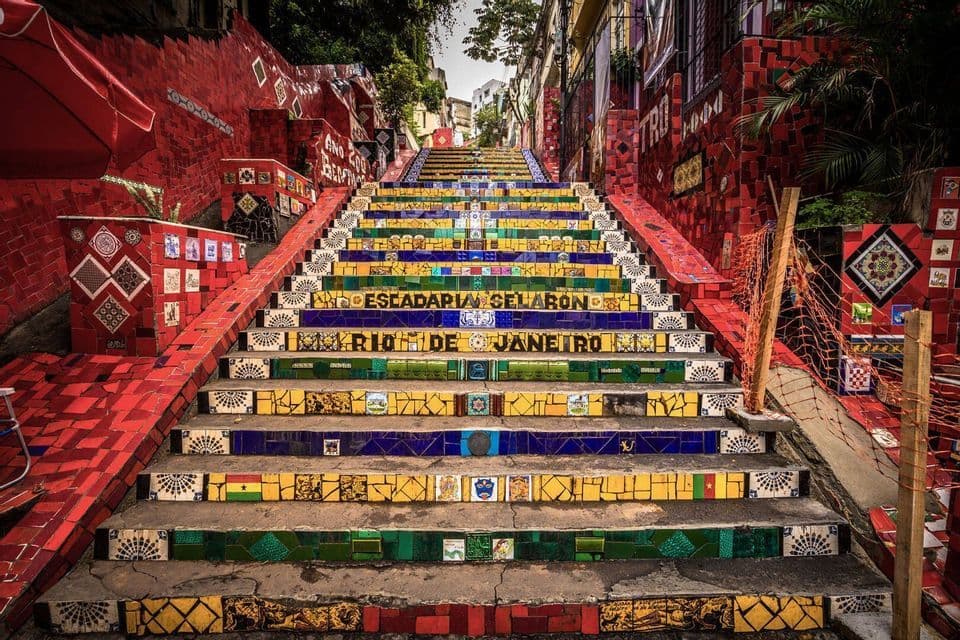 I gradini rivestiti di mosaico della Scalinata Selarón a Rio de Janeiro, affiancati da vivaci pareti di piastrelle rosse.