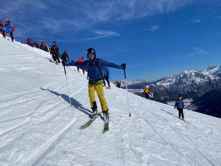 Eine WeRoad-Gruppenreise beim Skifahren an einem sonnigen Tag auf einer verschneiten Bergpiste