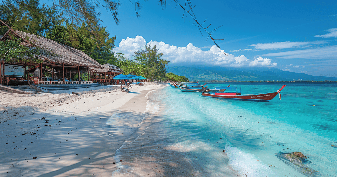 Boote sind in klarem türkisfarbenem Wasser an einem weißen Sandstrand vertäut, neben einer Strohdachhütte unter sonnigem Himmel.