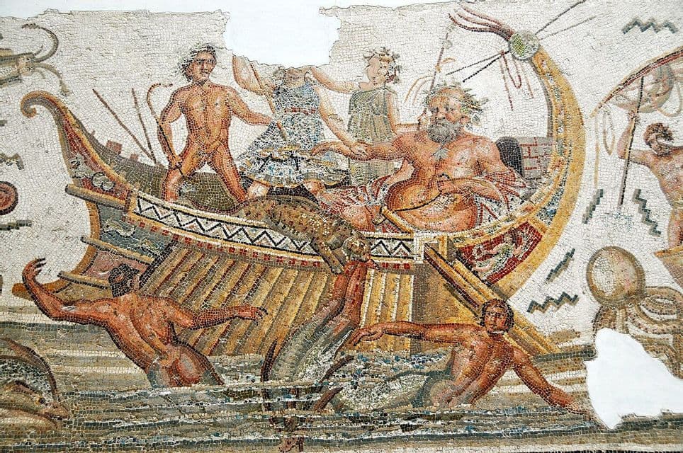 A close-up of an ancient Roman mosaic depicting a mythological scene of figures on an ornate ship at sea.