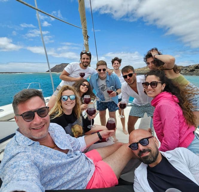 WeRoad Gruppenreise: Anstoßen mit Rotwein auf einem Segelboot an einem sonnigen Tag auf See.