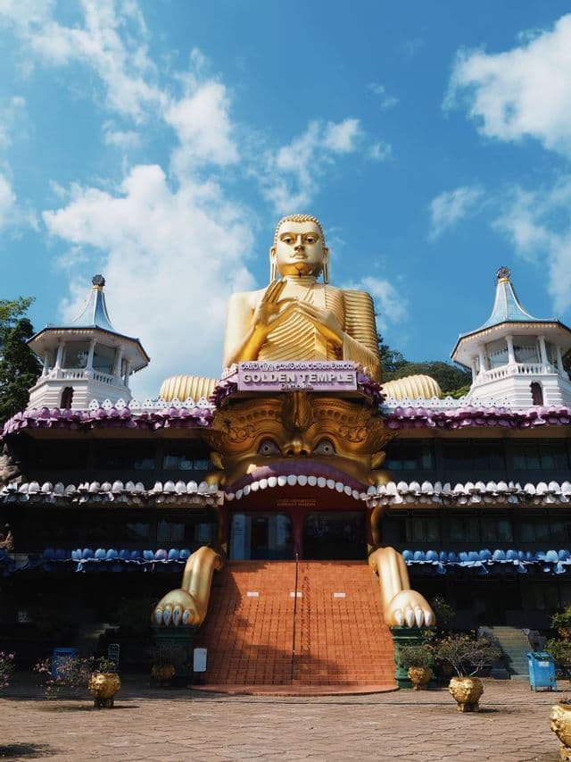 Une immense statue de Bouddha doré surplombe le Temple d'Or, dont l'entrée est sculptée en forme de grande gueule de monstre.