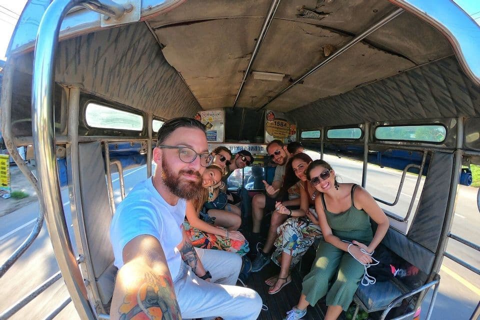 Eine lächelnde WeRoad-Gruppe macht ein Selfie in einem lokalen Transportmittel.