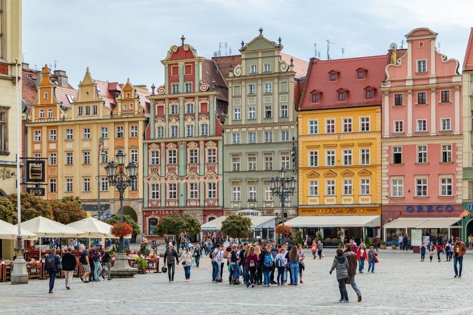Eine WeRoad-Gruppe traf sich auf einem Kopfsteinpflasterplatz, umgeben von farbenfrohen, verzierten historischen Gebäuden.