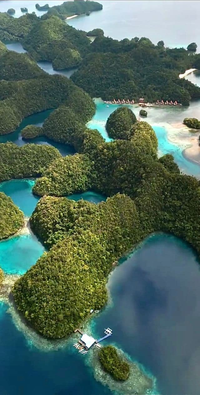 Vista aerea di numerose isole lussureggianti e coperte da foreste, sparse su uno specchio d'acqua turchese e blu intenso.