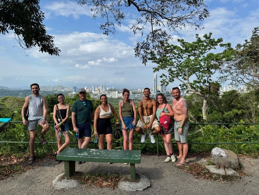 Un groupe WeRoad pose pour une photo sur un point de vue en hauteur avec une ville moderne en arrière-plan.