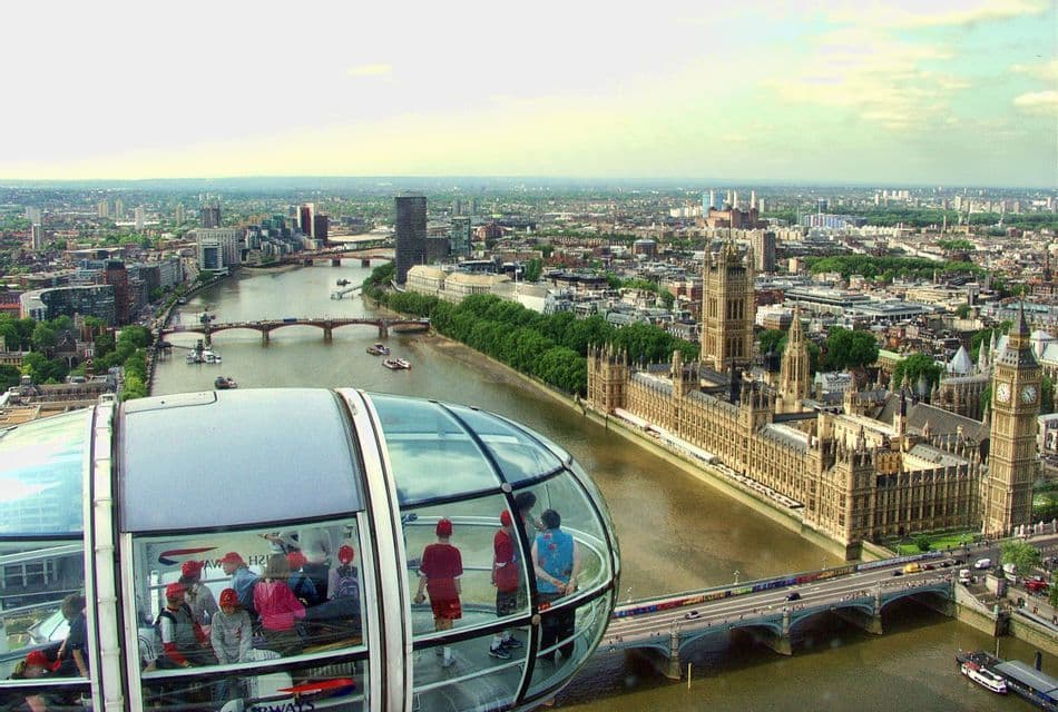 A WeRoad group trip viewing a cityscape with a river and historic buildings from inside a Ferris wheel capsule.