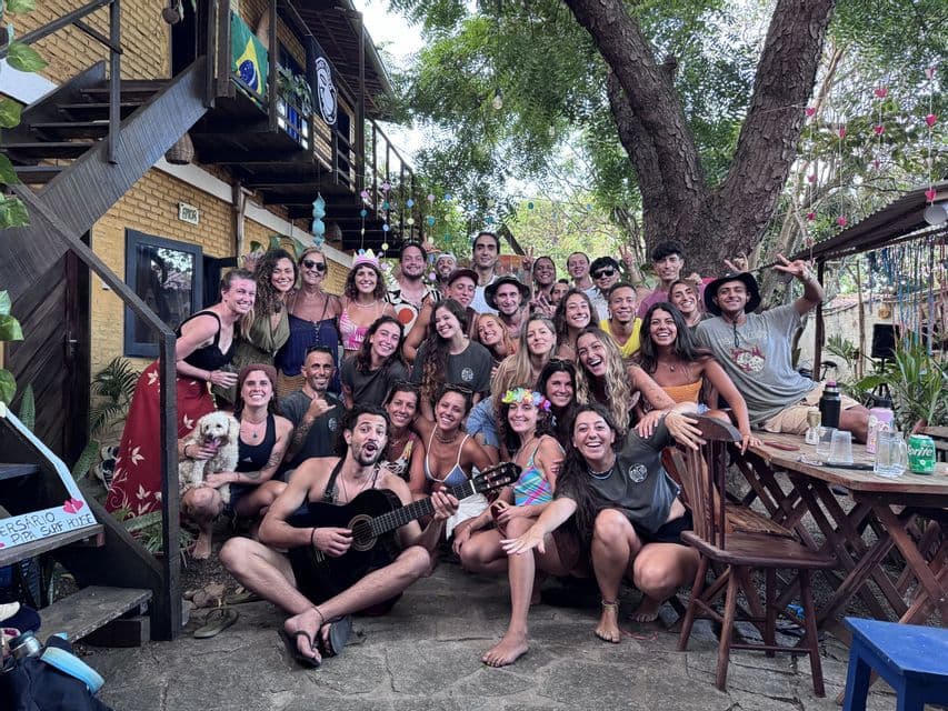 Un gruppo WeRoad in viaggio posa per una foto in un cortile, con una persona in primo piano che imbraccia una chitarra.