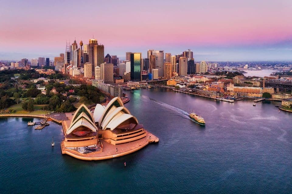 Sydney harbour and the Opera House at sunset Sydney harbour at sunset seen from above, with the Opera House in the foreground and the downtown skyline behind it.