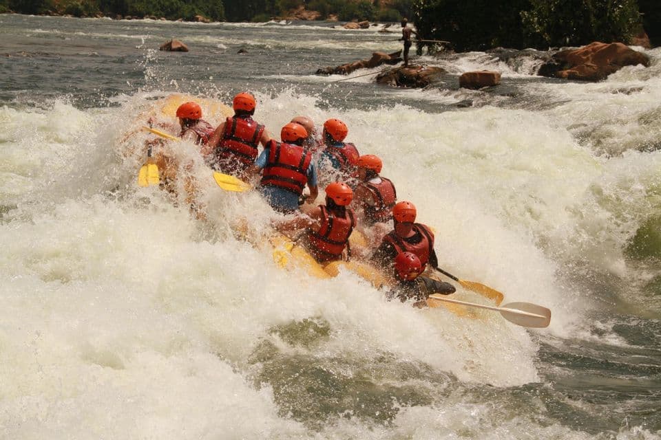 Eine WeRoad Gruppenreise beim Wildwasser-Rafting in einem gelben Boot durch große, spritzende Fluss-Stromschnellen.