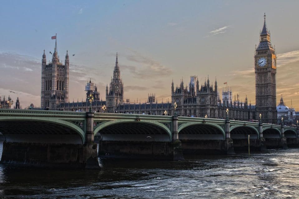 Ponte di Westminster che attraversa il Tamigi con il Palazzo di Westminster e il Big Ben sullo sfondo sotto un cielo al tramonto.