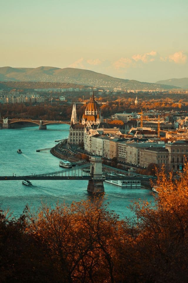 Una veduta aerea di una città con un ampio fiume, numerosi ponti e un edificio a cupola ornato sulla riva.
