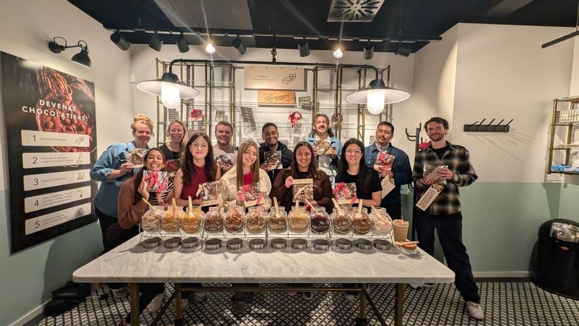 Un viaje en grupo de WeRoad posando con sus chocolates artesanales en un taller de elaboración de chocolate.