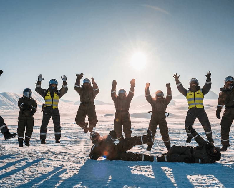 Un viaje en grupo de WeRoad con ropa de invierno posando y saltando juguetonamente en un paisaje nevado bajo el sol.