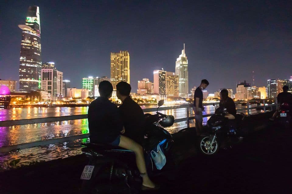 Saigon by scooter at night A scooter above the Ho Chi Minh City skyline at night