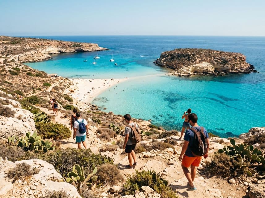 Un viaggio di gruppo WeRoad cammina lungo un sentiero costiero roccioso verso una caletta sabbiosa con acqua turchese