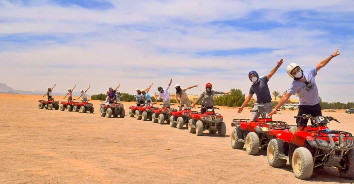 WeRoad Gruppenreise: Teilnehmer posieren mit ausgestreckten Armen auf roten Quads in der Wüste.