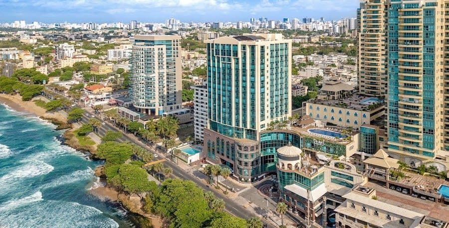 Vista aérea de una ciudad moderna con hoteles de gran altura a lo largo de una costa rocosa junto a un mar turquesa.